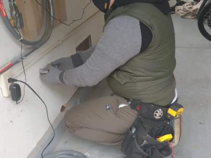Electrician performing outlet wiring in a Palestine garage